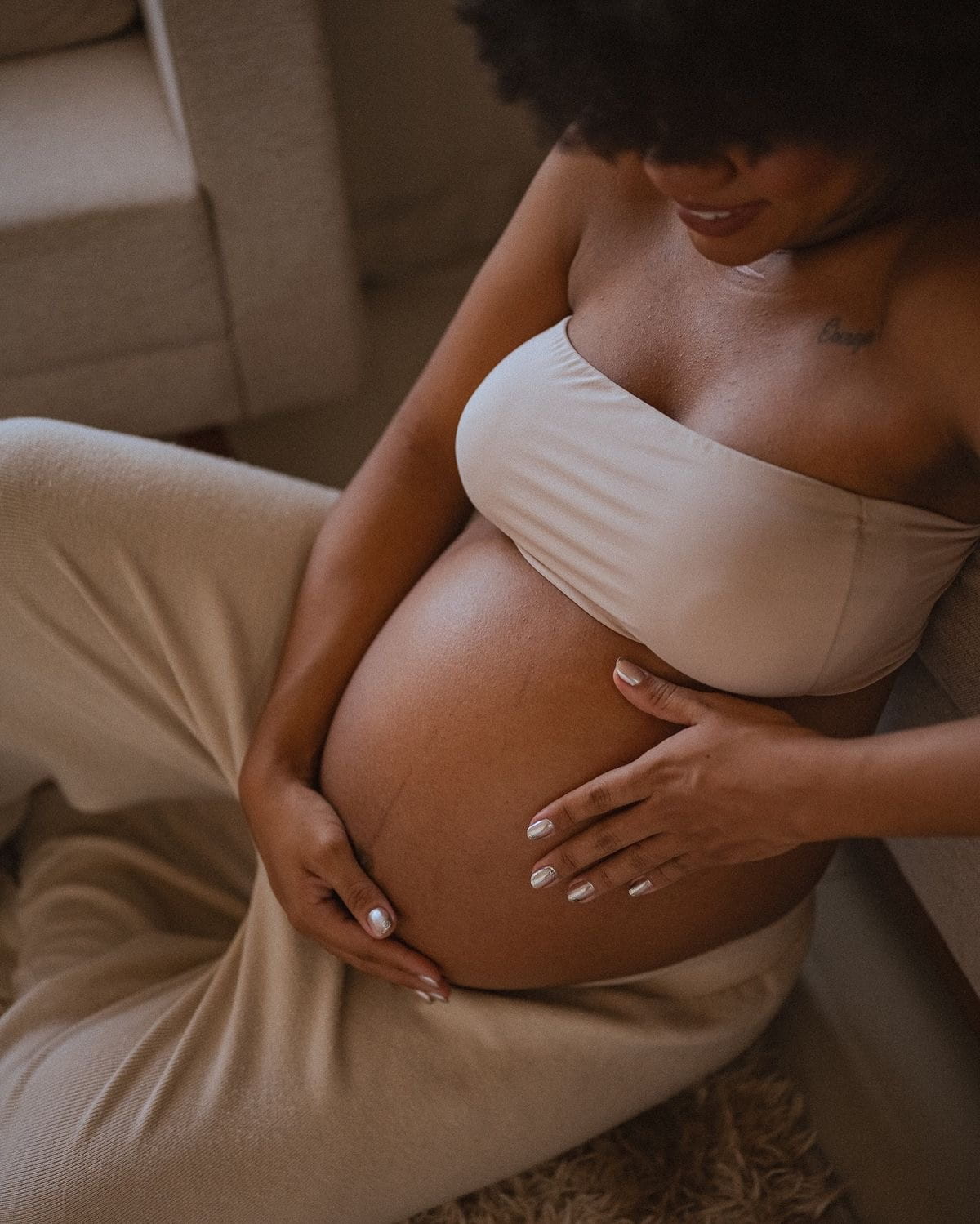 Silhouette of pregnant mother behind linen sheet in golden outdoor light